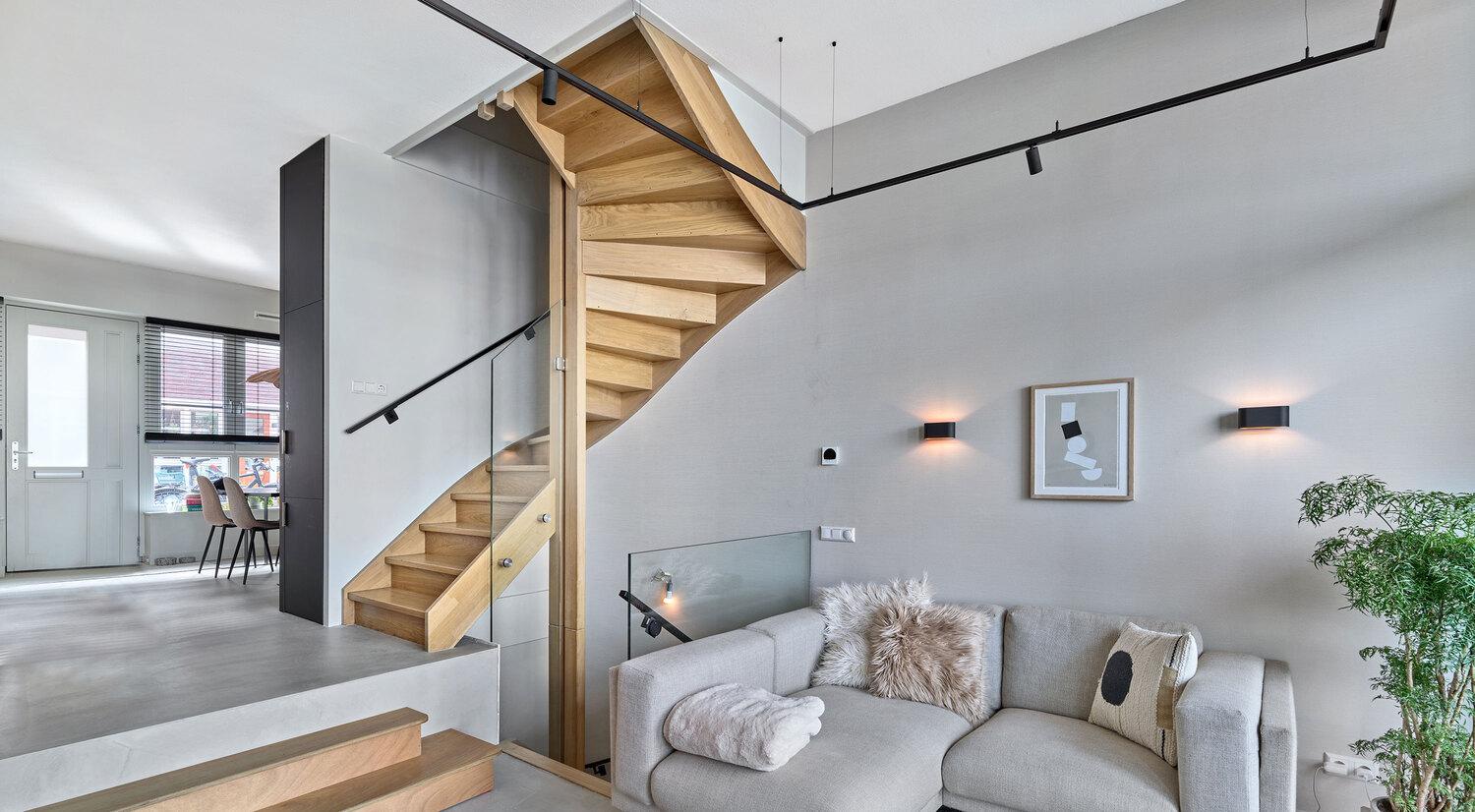 Modern living room with wooden staircase and Acosorb acoustic ceiling