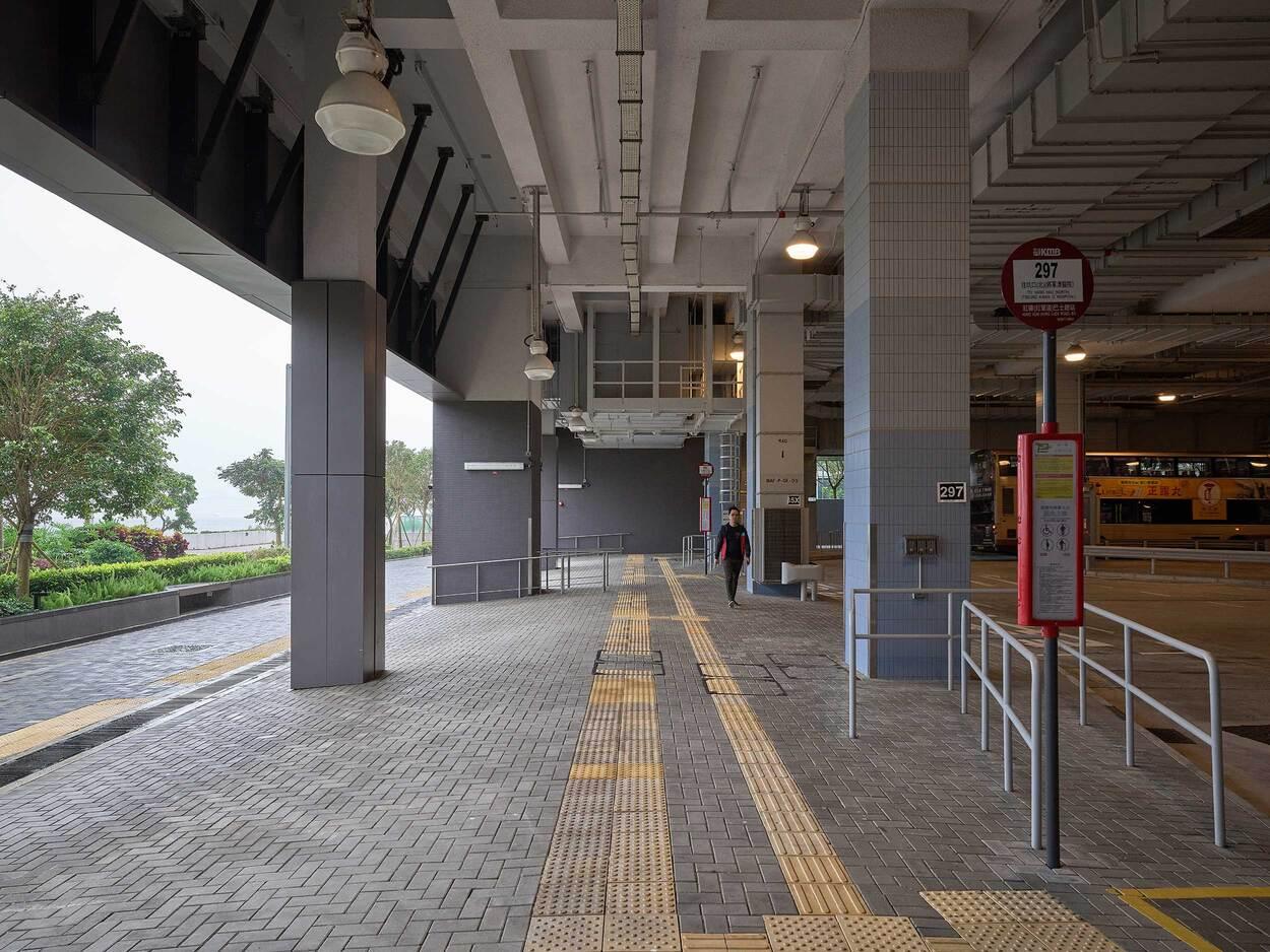 Covered urban train station platform with tactile paving and signage in Japan
