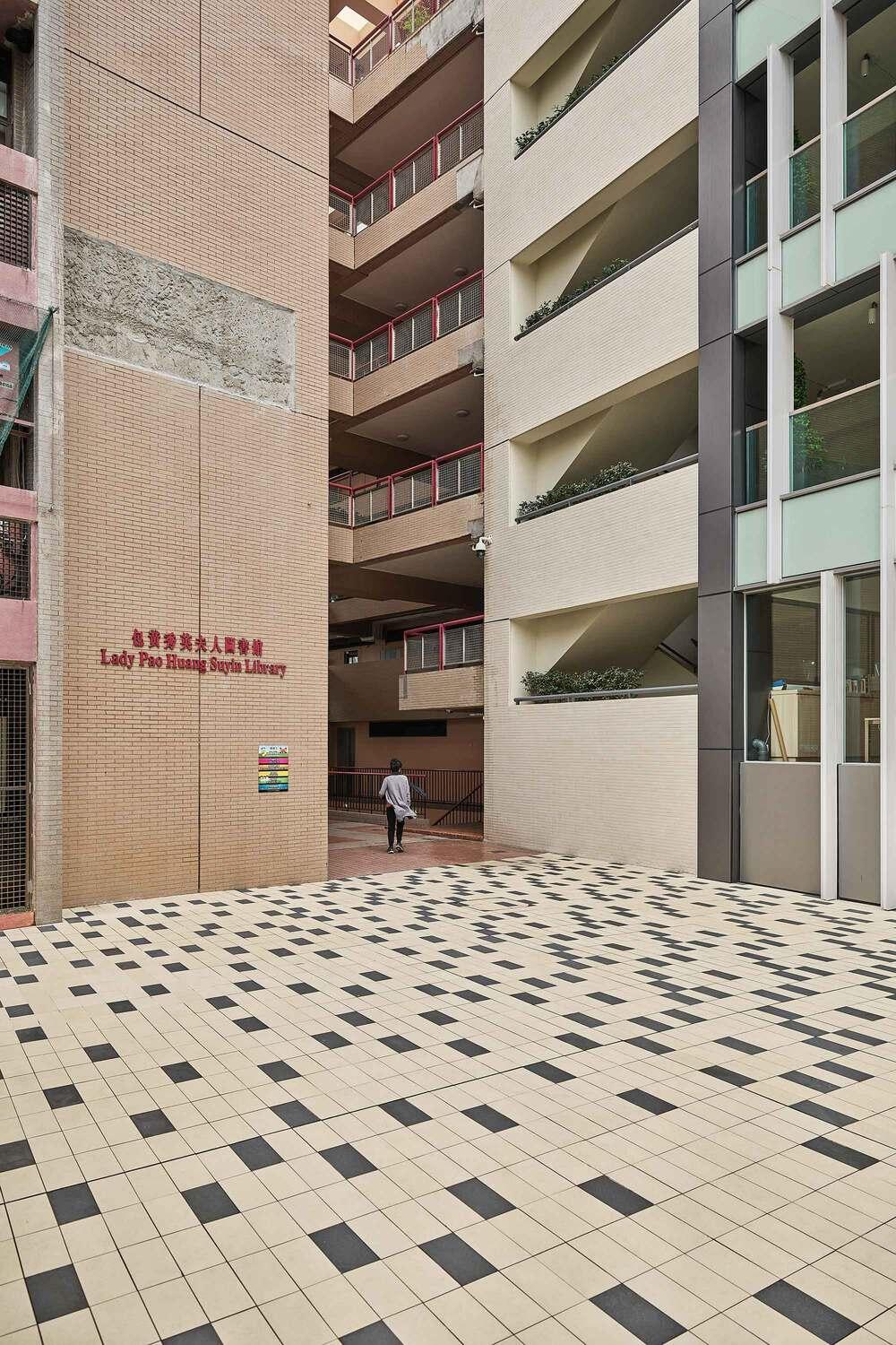 Narrow corridor between modern buildings with patterned tiled floor